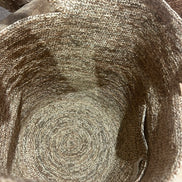Intérieur d'un sac en raphia naturel tressé avec anse, posé sur un fond en bois rustique