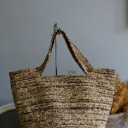 Sac cabas tressé en fibres naturelles marron et beige sur support métallique