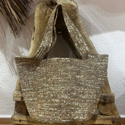 Sac cabas en raphia tressé marron suspendu sur une chaise rustique en bois