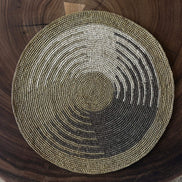 Set de table rond en raphia tissé avec motif géométrique en nuances de vert sur table bois