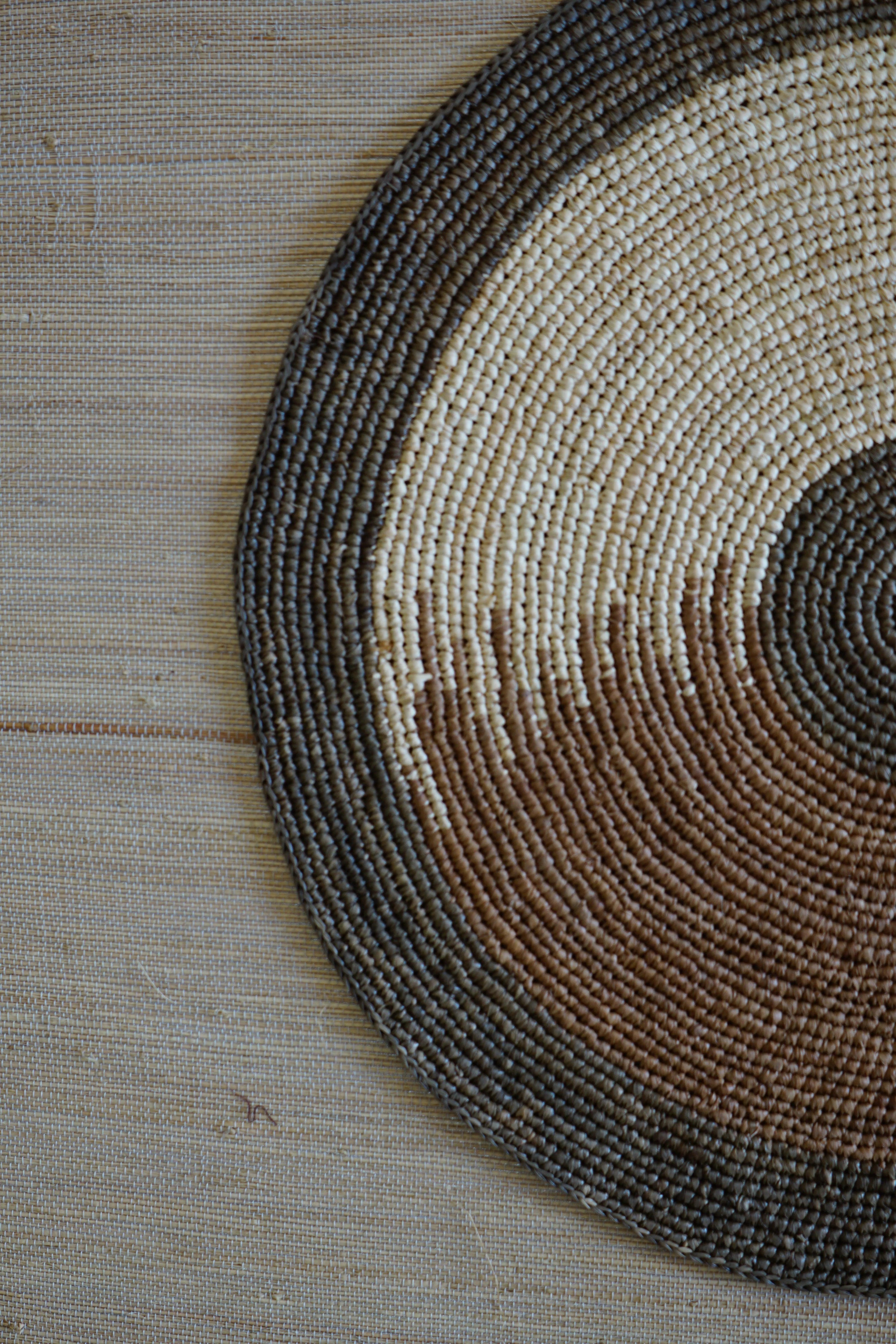 Set de table en raphia Vision de OQENA : set de table artisanal fait à la main avec des fibres naturelles de Madagascar et un design élégant.